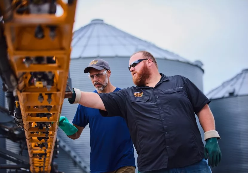 Farmers Inspecting Equipment