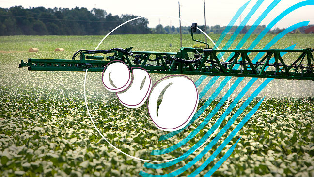 A sprayer boom spraying a soybean crop. The image has 3 illustrated soybeans in the middle of it. 