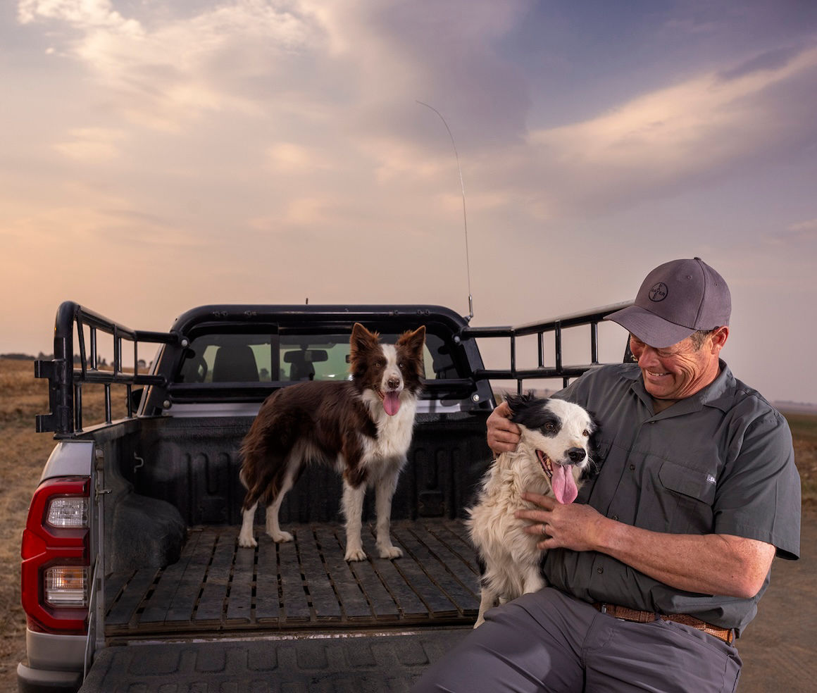 Smiling Farmer Hugging A Dog