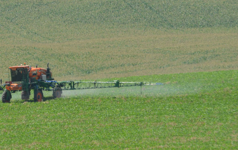 trator pulverizador em um campo ilustrando artigo sobre a importância das últimas aplicações de fungicidas na soja