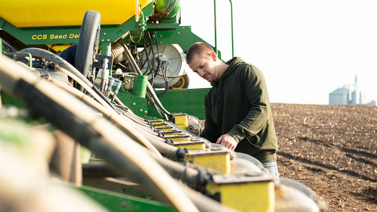 Farmer prepping planting equipment for planting soybeans