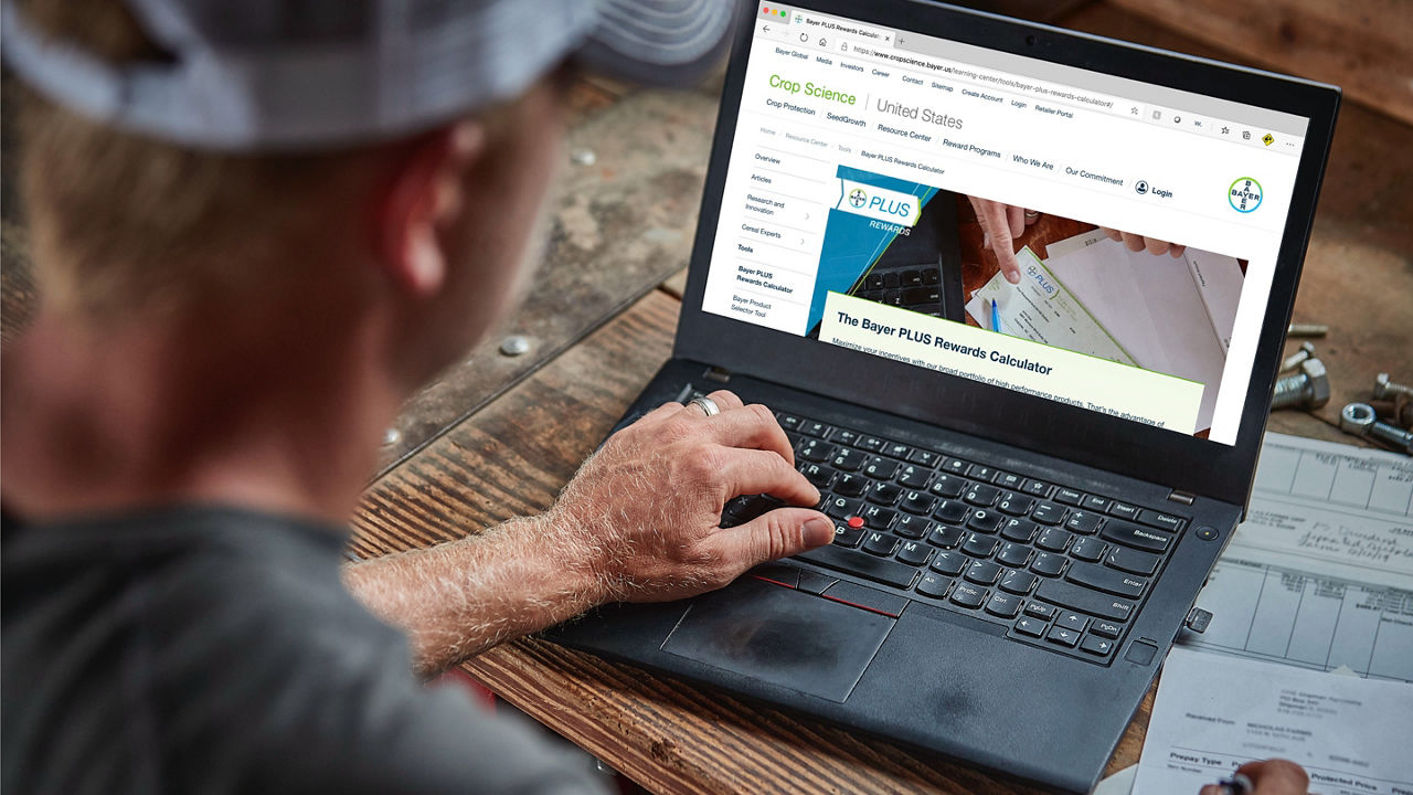 Farmer viewing the Bayer plus rewards program  from their laptop
