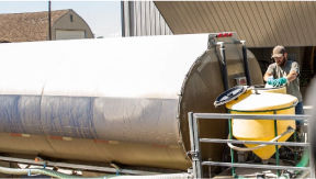 A farmer adds chemicals to a mixing tank in preparing for spraying 