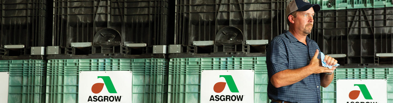 Farmer wiping his hands next to Asgrow proboxes