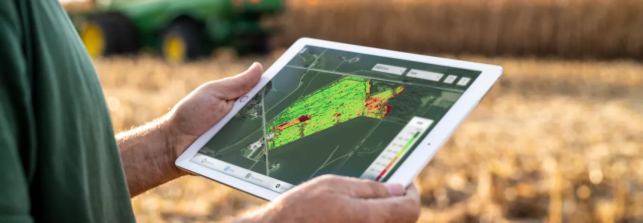 Farmer in Field using Climate FieldView on iPad