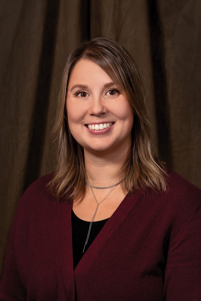 Headshot of Kaeley Kindrachuk in front of a dark backdrop 