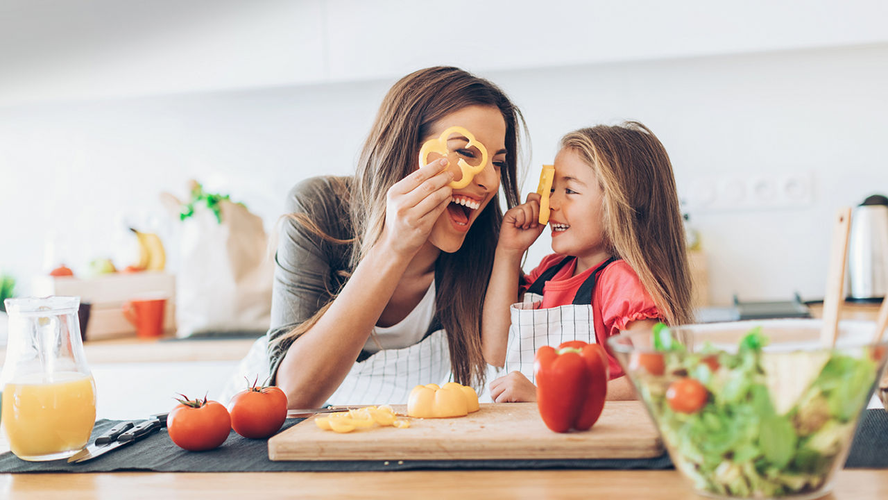 Moeder en kind met paprika en tomaat