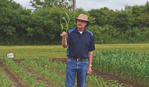 Peter Sikkema, professor of field crop weed management at the University of Guelph discusses a small plot corn trial while standing in a field.