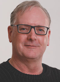 A portrait of a man in black glasses and black shirt. The man is Robert Wauters, site lead for Bayer’s commercial production and breeding site in Lethbridge.