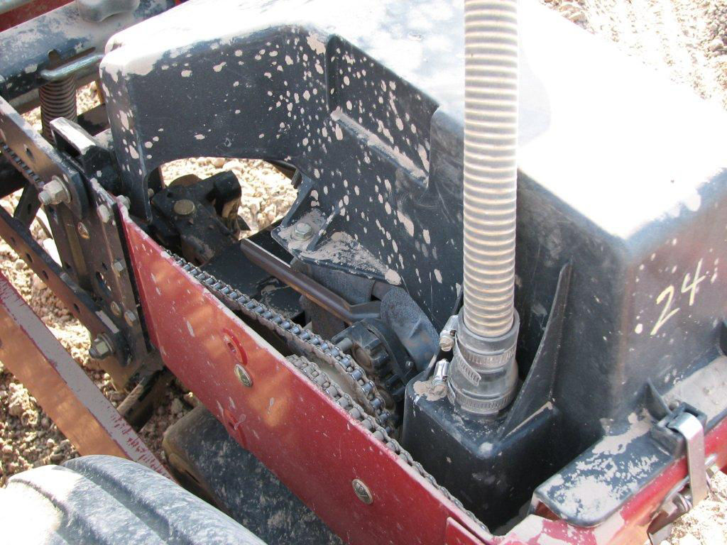 Soybean seed planting equipment with gears, chains, and tubes exposed.